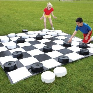 Two children enjoying a game of Giant Checkers or Drafts.