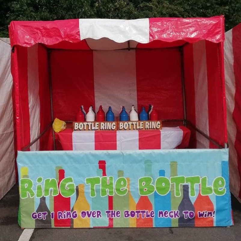 Our bright red and white striped Fete Game Side Stall set up with our Ring the Bottle game.