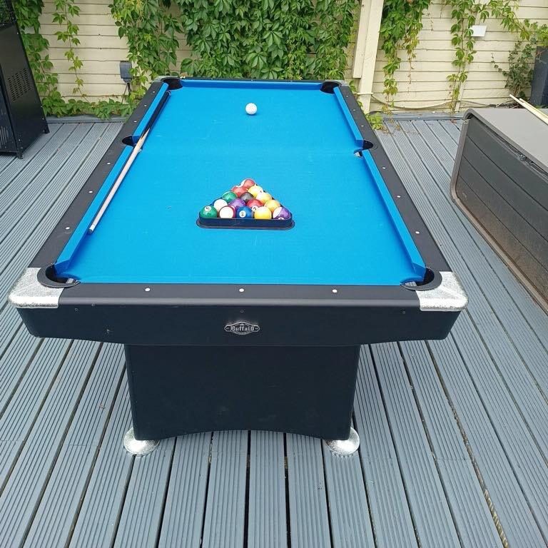 Our Pool Table with a blue felt cover and black surround, set up ready with pool balls in the triangle.