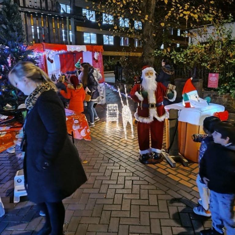 Our life-sized Singing Santa with crowds of people outside on the bricked street enjoying our Christmas Side Stalls games and decorations.