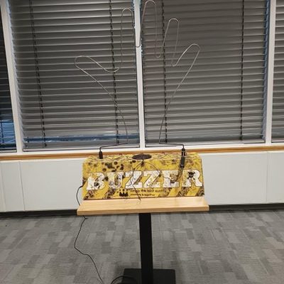 Giant Buzzer Our Giant Buzzer set up with its camouflage patterned base, metal tong and wire in the shape of a hand.