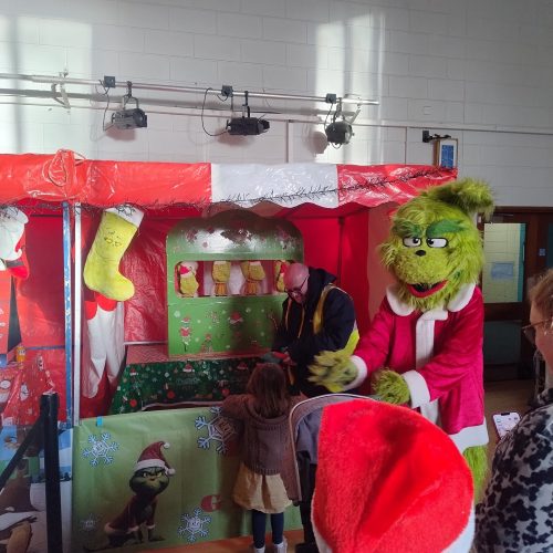 Down the Grinch Side Stall with a Grinch Mascot